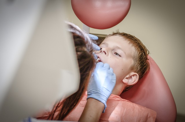 Zubní lékař ošetřuje v křesle malého chlapce