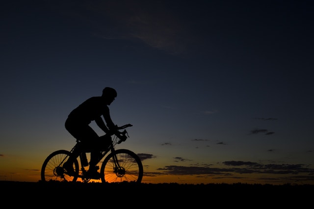 muž na kole při západu slunce